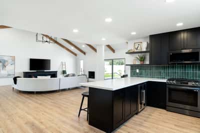 The spacious kitchen flows effortlessly into the dramatic great room, creating an inviting atmosphere highlighted by designer finishes, oversized gathering spaces, and seamless indoor-outdoor living.