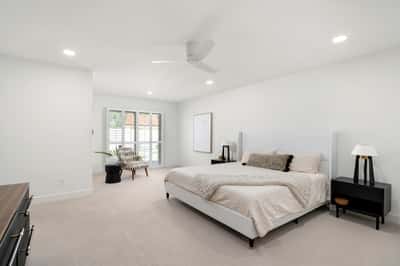Unwind in this spacious primary suite featuring plantation shutters, soft natural light, generous proportions, and a peaceful atmosphere designed for comfort after a busy day.