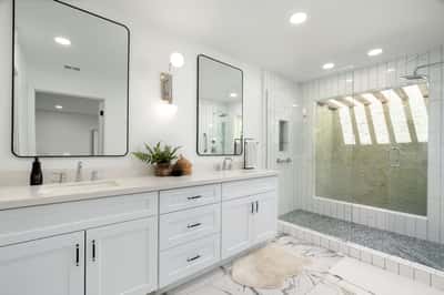 Thoughtfully updated with dual sinks, quartz counters, oversized framed mirrors, and a spacious walk-in shower, this elegant primary bath offers a spa-inspired experience designed for everyday comfort.