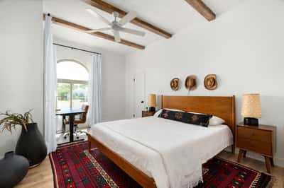 Exposed ceiling beams, rich wood flooring, and generous natural light define this versatile bedroom, offering flexible use as a guest room, office, or private retreat within this beautifully updated Scottsdale home.