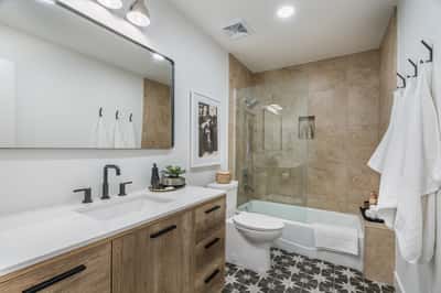 Modern finishes, elegant tile work, a sleek vanity, and updated fixtures make this beautifully renovated bathroom both functional and stylish, complementing the home's extensive renovations.