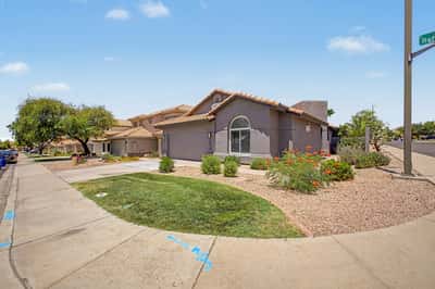 Wide exterior perspective highlighting the home's attractive landscaping, spacious frontage, and inviting neighborhood atmosphere. A wonderful place to enjoy comfortable living in Mesa.