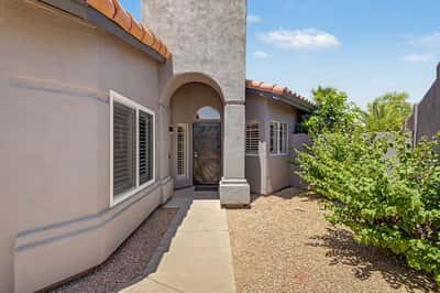 Spacious foyer with high ceilings, designer light fixtures, tile flooring, plantation shutters, and custom built-in cabinetry. A welcoming first impression that flows beautifully into the main living spaces.