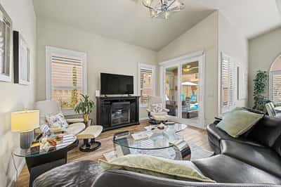 Spacious living room showcasing soaring ceilings, large windows, stylish flooring, and a cozy fireplace. The thoughtfully designed layout offers comfort and functionality throughout.