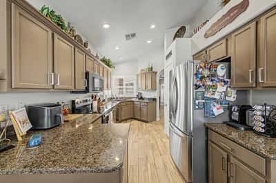 Well-equipped kitchen offering granite countertops, stainless steel appliances, extensive cabinetry, and recessed lighting. A beautiful combination of style, storage, and functionality.