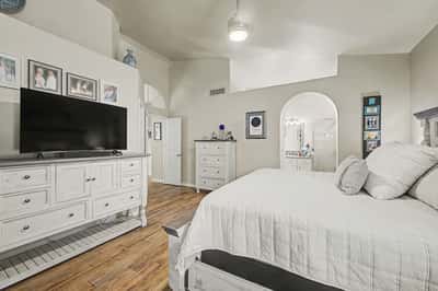 Bright primary suite with soaring ceilings, updated finishes, generous space, and convenient access to the ensuite bathroom. A comfortable retreat that balances elegance and functionality.
