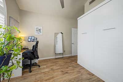 Flexible living space featuring tile flooring, abundant natural light, plantation shutters, and vaulted ceilings. Easily serves as a bedroom, office, or hobby room.