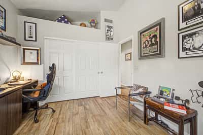Inviting guest bedroom with plantation shutters, durable tile flooring, and plenty of natural light. A flexible room that offers comfort for family, visitors, or remote work.
