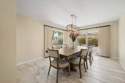 Filled with natural light, this spacious dining room features large sliding doors leading to the backyard patio, creating seamless indoor-outdoor living and an ideal setting for entertaining.
