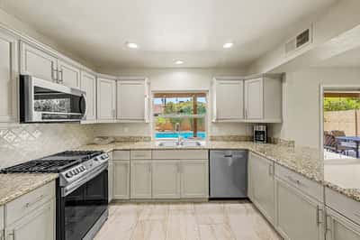 Bright and welcoming, this gourmet kitchen offers extensive granite countertops, updated cabinetry, stainless steel appliances, and scenic backyard views that make meal preparation enjoyable every day.