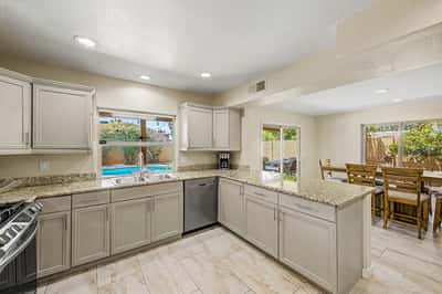 Designed for entertaining, this spacious kitchen features abundant granite counter space, stainless steel appliances, updated cabinetry, and an open layout connecting seamlessly with nearby living and dining areas.