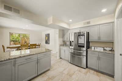 The kitchen's open-concept design provides easy access to the dining area while offering extensive cabinetry, granite countertops, and plenty of prep space. An ideal setup for hosting family and friends.