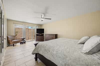 Spacious primary suite with updated tile flooring, ceiling fan, abundant natural light, and direct outdoor access. A peaceful retreat designed for comfort, privacy, and relaxation in Scottsdale.