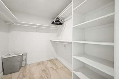 Organized walk-in closet featuring extensive shelving, hanging space, and convenient built-in storage. An ideal solution for keeping wardrobes and accessories neatly arranged.