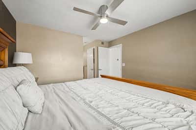 Inviting secondary bedroom with wood-look flooring, ceiling fan, neutral d cor, and generous space for guests or family. A bright and comfortable room within this Scottsdale home.