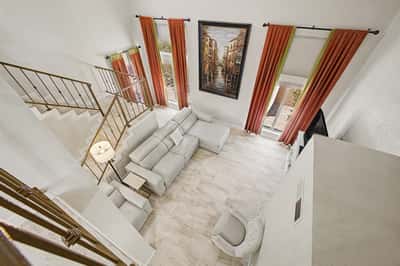 Bird's-eye view of the open-concept great room highlighting soaring ceilings, expansive windows, and upgraded flooring. Bright, spacious living designed for entertaining and everyday comfort.
