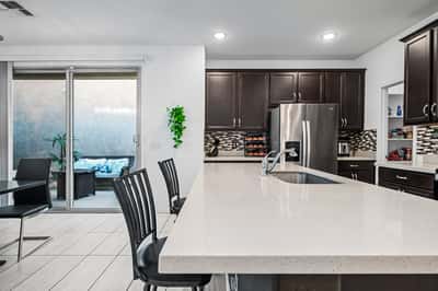 Spacious kitchen with expansive island, breakfast bar seating, and sliding door access to the covered patio. A bright and functional layout ideal for Arizona indoor-outdoor living.