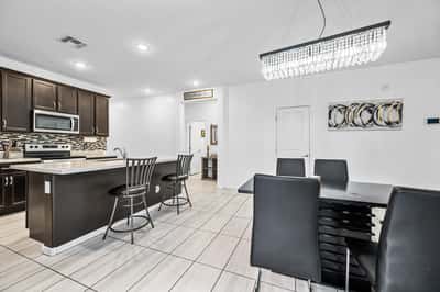 Bright dining room with breakfast bar seating adjacent to the modern kitchen. The open layout makes entertaining and everyday dining both convenient and enjoyable.