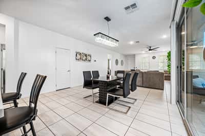 Dining area opening directly into the spacious great room, creating an ideal space for entertaining and family gatherings. Large windows and patio access enhance the bright, open feel.