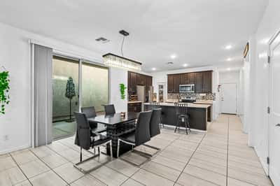 Elegant dining room overlooking the kitchen and breakfast bar, offering a spacious setting for everyday meals and special occasions. The open design enhances the home's comfortable flow.