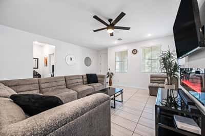 Spacious family room featuring contemporary finishes, recessed lighting, ceiling fan, and an electric fireplace. A comfortable gathering place that complements the home's open-concept design.