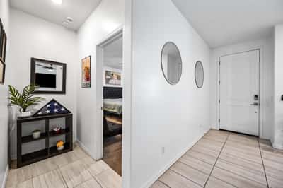Welcoming interior hallway showcasing modern flooring and easy access to the primary bedroom and main living spaces. A thoughtfully designed layout enhances the home's functionality.