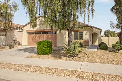 Inviting single-story home with mature landscaping, a spacious driveway, attached 2-car garage, and attractive curb appeal in the highly desirable Palm Valley community of Goodyear.