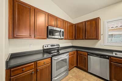 Functional kitchen featuring beautiful wood cabinetry, stainless steel appliances, abundant counter space, and plenty of storage, creating an ideal space for daily cooking and entertaining.