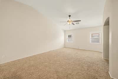 Generous family room with high ceilings, natural light, and versatile space that easily accommodates everyday living, entertaining, or relaxing with family and friends.