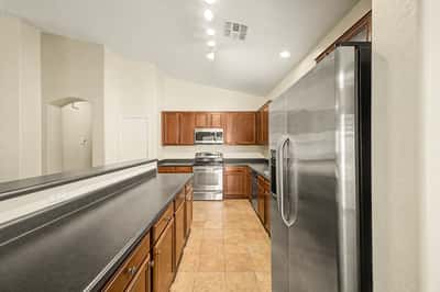 Well-designed kitchen featuring extensive cabinetry, stainless steel appliances, generous prep space, and a large breakfast bar perfect for casual dining and entertaining.