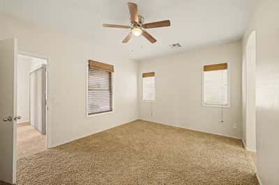 Expansive primary suite filled with natural light, neutral finishes, and comfortable living space designed for relaxation and everyday comfort.