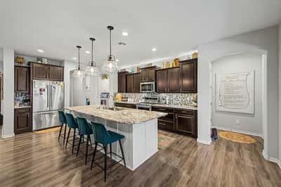 Open-concept kitchen with granite countertops, oversized island, abundant cabinetry, recessed lighting, and seamless flow into the main living spaces, creating an inviting gathering place.