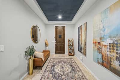 Bright front entry with upgraded flooring, architectural details, custom wood door, and designer touches that offer a warm and inviting introduction to the home's spacious interior.