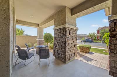 Comfortable covered porch with outdoor seating provides a peaceful space to relax while enjoying attractive landscaping and the charming streetscape of this desirable Mesa neighborhood.