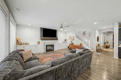 Large great room offers an open layout with custom built-ins, designer fireplace, luxury flooring, and effortless flow into the gourmet kitchen for entertaining.