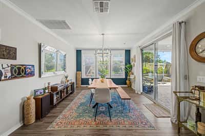 Beautiful dining room features large windows, designer chandelier, upgraded flooring, and direct access to the outdoor living area, perfect for hosting family meals and celebrations.