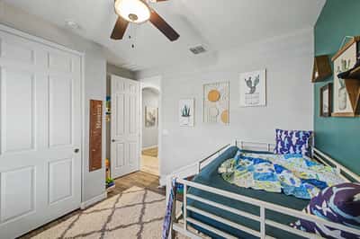 Alternate angle of the secondary bedroom highlights upgraded flooring, stylish d cor, natural light, and a functional layout that complements the home's thoughtful design.