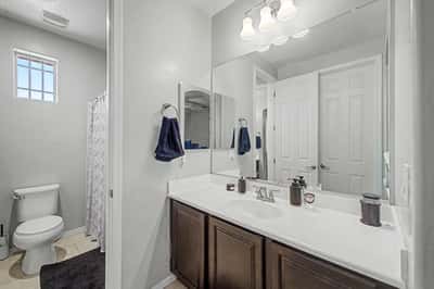 Ensuite bathroom offers a large vanity, modern cabinetry, quality fixtures, and convenient access, complementing the home's spacious bedroom layout.