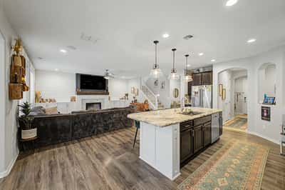 Spacious open-concept design showcases the oversized kitchen island, granite countertops, custom cabinetry, and a welcoming family room ideal for entertaining and everyday living.