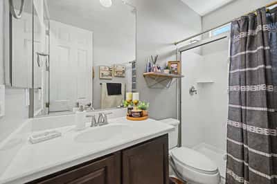 Well-appointed bathroom features a contemporary vanity, updated fixtures, walk-in shower, and stylish finishes, providing comfort and convenience for family and guests.