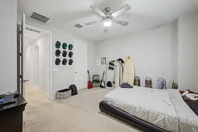 Oversized bedroom provides exceptional flexibility with generous square footage, plush carpeting, ceiling fan, and room for multiple furniture arrangements.