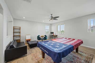 Expansive bonus room features upgraded flooring, recessed lighting, ceiling fan, and multiple windows, making it ideal as a game room, media room, home office, or additional family living space.