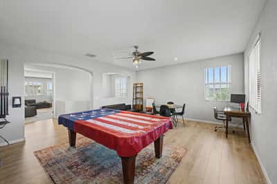 Open recreation room features upgraded flooring, ceiling fan, recessed lighting, and flexible space for games, entertaining, or creating a personalized lifestyle area.