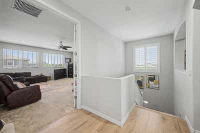 Open landing provides seamless flow between the upper-level living spaces while showcasing natural light, neutral finishes, and an inviting layout throughout the home.