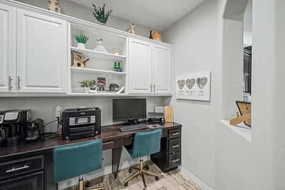Built-in office area offers custom cabinetry, dual desks, ample storage, and a practical workspace perfect for remote work, homework, or household organization.