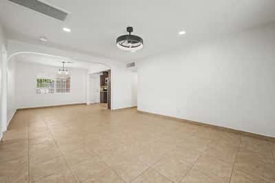 Large family room offering durable tile flooring, recessed lighting, and an open connection to the dining area and kitchen, making it ideal for entertaining and everyday comfort.