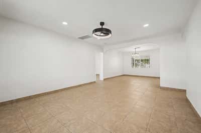 Spacious great room with an open layout, neutral finishes, tile flooring, recessed lighting, and seamless flow into the dining area, offering flexible living space for a variety of lifestyles.