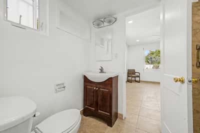 Functional bathroom vanity area with a wood vanity cabinet, modern sink, mirror, natural light, and direct access to the connected bedroom. Clean finishes and practical storage enhance the everyday convenience of this Phoenix home.