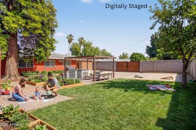 Digitally staged concept transforms the backyard into an inviting outdoor oasis featuring a pergola, built-in grilling station, entertaining space, and lush landscaping. This rendering showcases the outdoor potential of this Phoenix home.