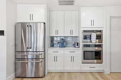 Built-in double ovens, stainless steel refrigerator, and extensive cabinetry provide convenience, storage, and premium finishes that elevate this beautifully renovated Scottsdale kitchen.
